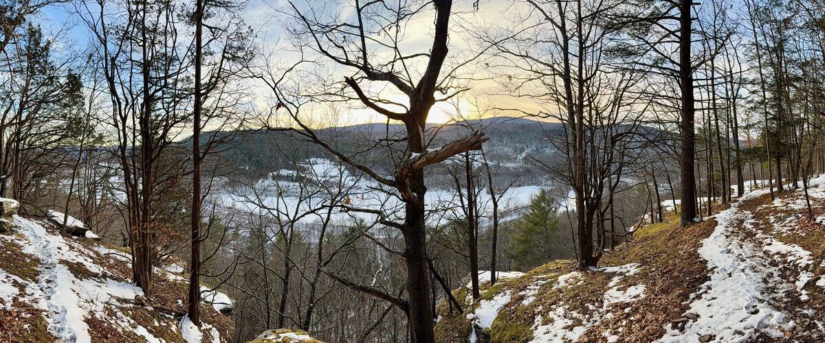 Prattsville, NY, USA - Dec 27, 2024. Uphill, short mountain hike to Pratt Rock. Mount Rushmore of upstate New York. Cliff stone carving for Zadock Pratt. Nearby dog and horse tombstone, valley view.