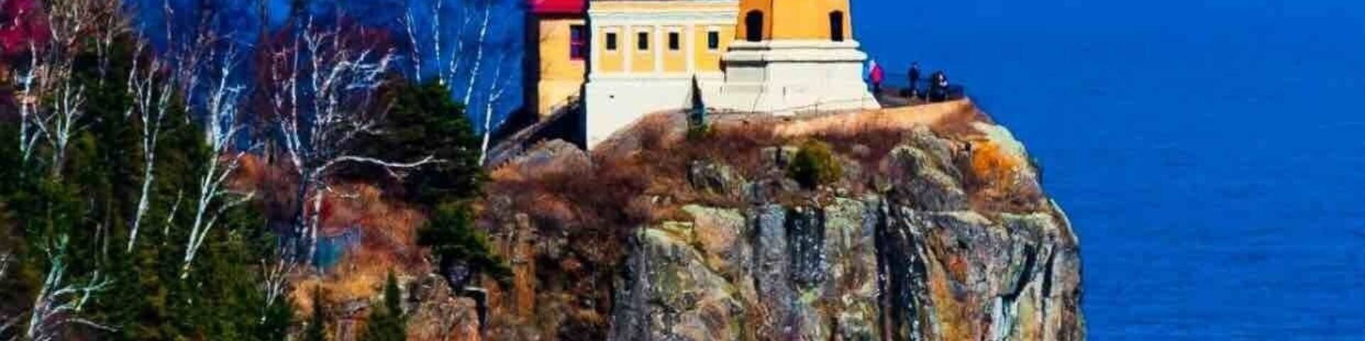 A lighthouse on a rocky cliff overlooking the ocean.