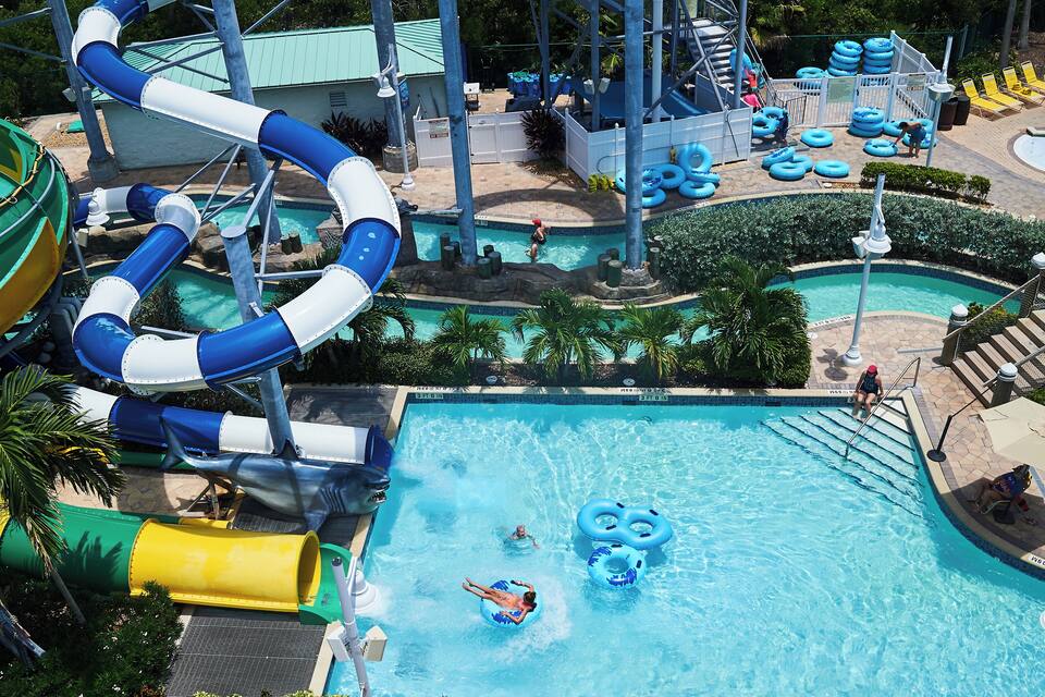 A water park with a large pool, slides, and inflatable rings.