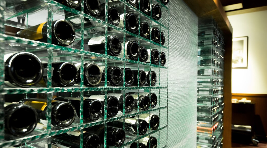Modern Wine Cellar rack with many tens bottles brand on shelf and put on temper thick glass shelf, in temperature control room to keep winecellar fresh long time