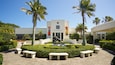The Vero Beach Museum of Art with a central sculpture, palm trees, and a paved walkway.