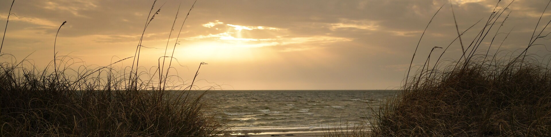 Sunset between grassy dunes Cape Hatteras National Seashore