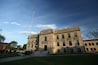 A large, historic building with a prominent flagpole and a sign reading "Miller County Courthouse."