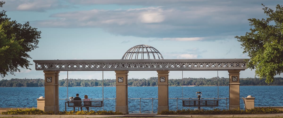 A couple sits on a swinging bench by Lake Monroe in downtown Sanford, Florida.