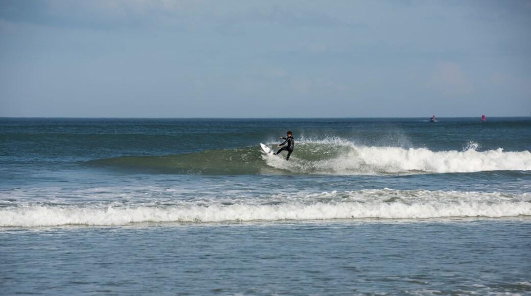 A lone male surfer wearing a black wet suit cutting back on wave as he surfs Florida's east coast near Daytona Beach, USA.