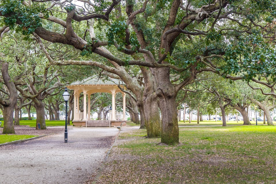 Um gazebo cercado por árvores grandes em um parque.