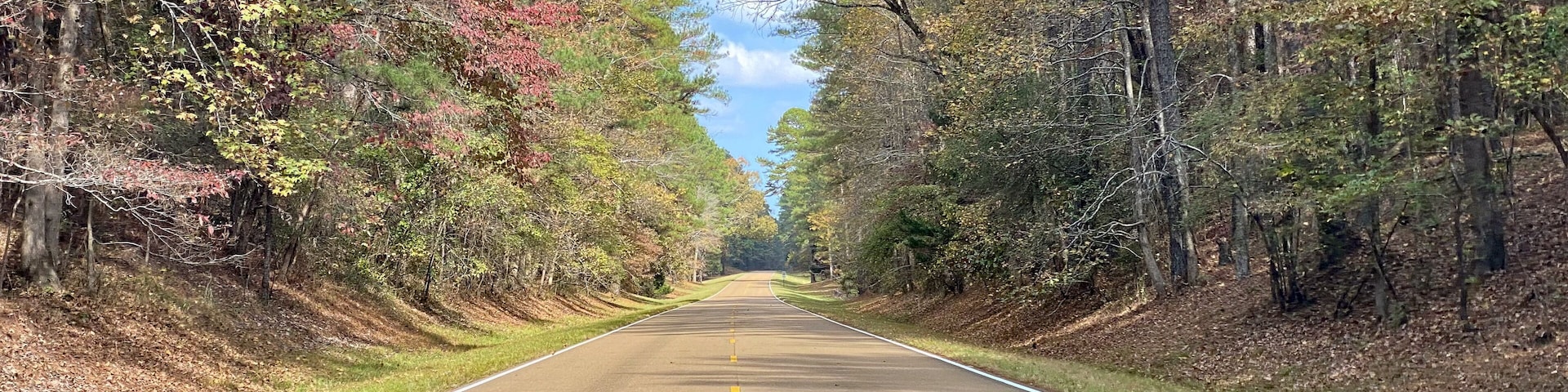 Natchez Trace Parkway a National Park Service scenic road and old route from Natchez, Mississippi to Cumberland River in Tennessee. No traffic on a road lined with autumn trees and fall foliage.
