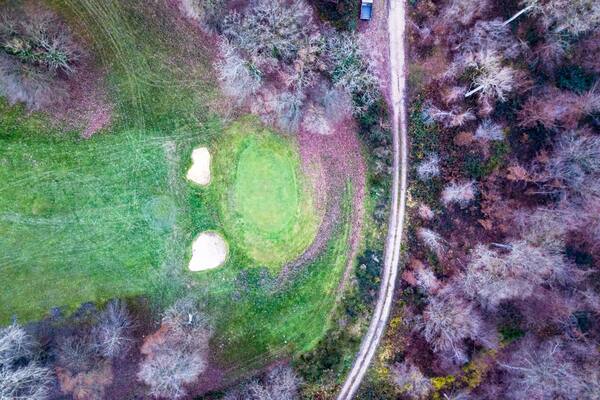 Drone view of a golf course with beautiful nature and a footpath
