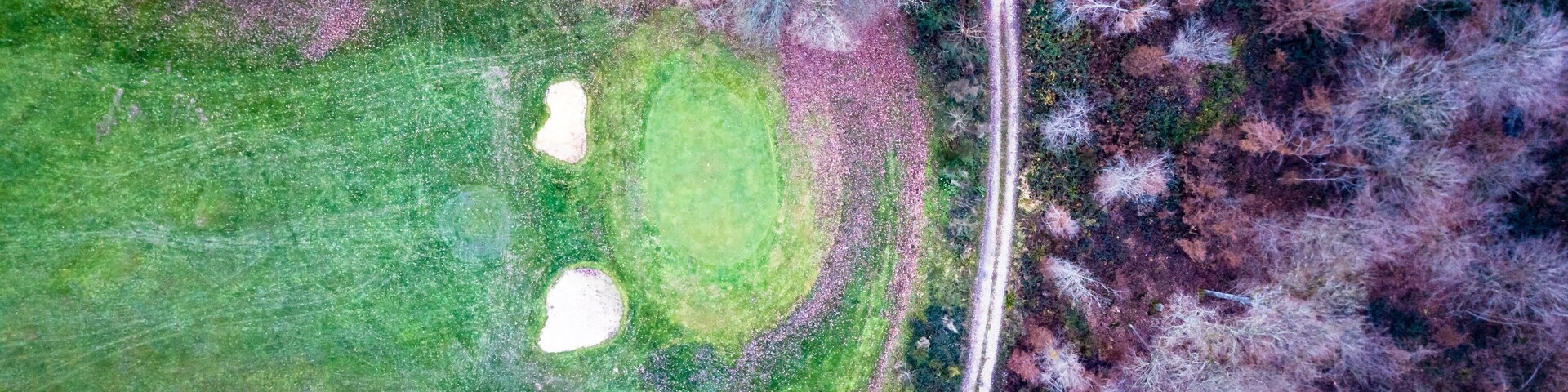 Drone view of a golf course with beautiful nature and a footpath
