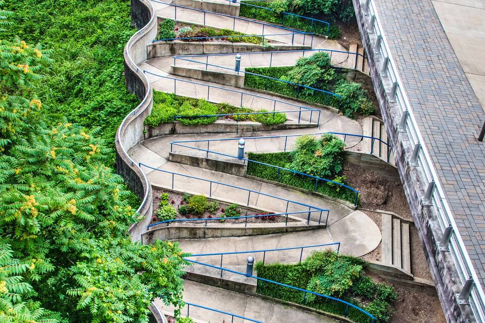 A series of terraced gardens with blue railings and a stone wall.