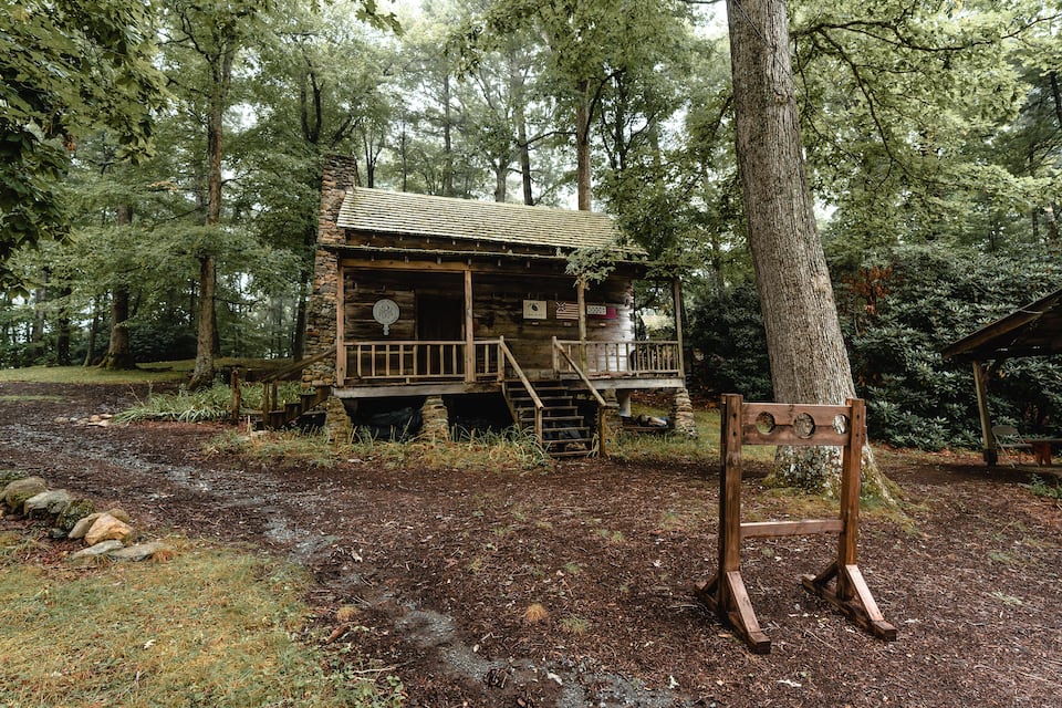 Een rustieke hut omringd door dicht bos.
