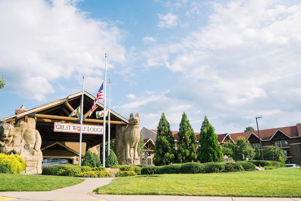 A building with a sign reading "Great Wolf Lodge" and a stone wolf statue in front.