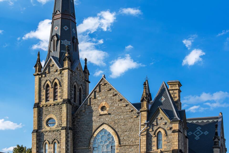 A historic church with a tall steeple and large arched windows.