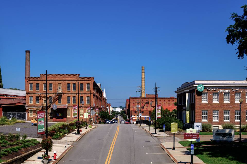 A historic downtown street with brick buildings, a water tower, and a science center.