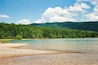 A lake surrounded by dense green forest and hills.