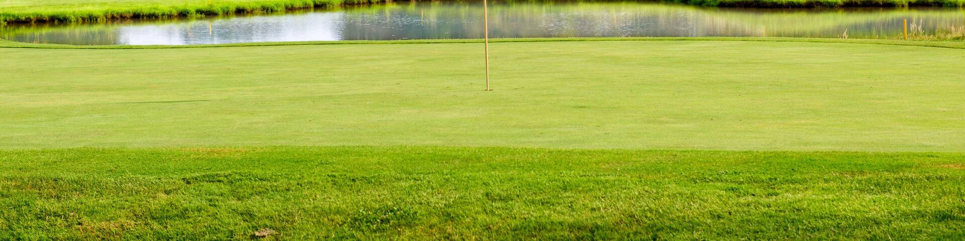 Golf course with a red flag on a summer day