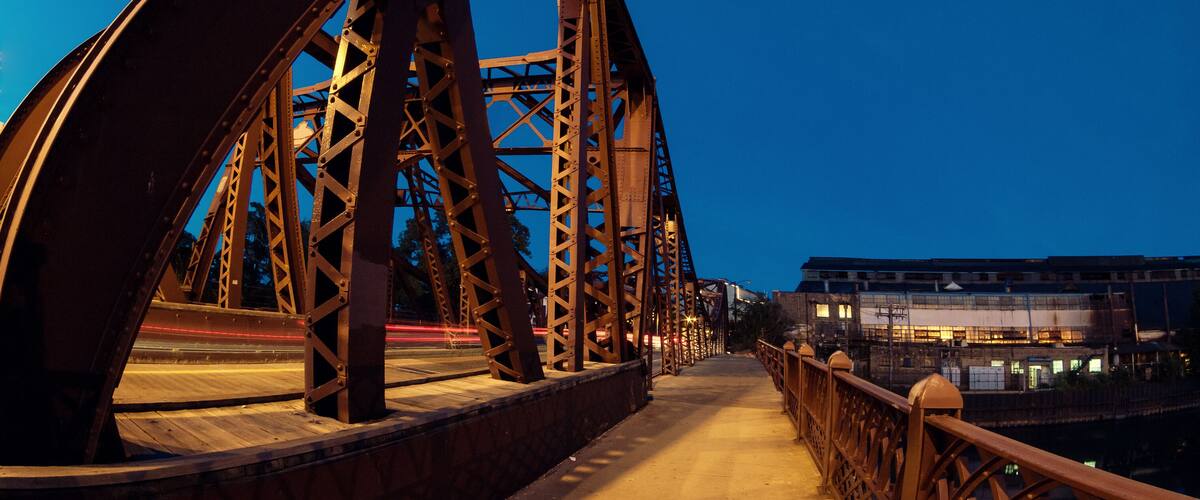 Vintage river bridge and industrial building at night