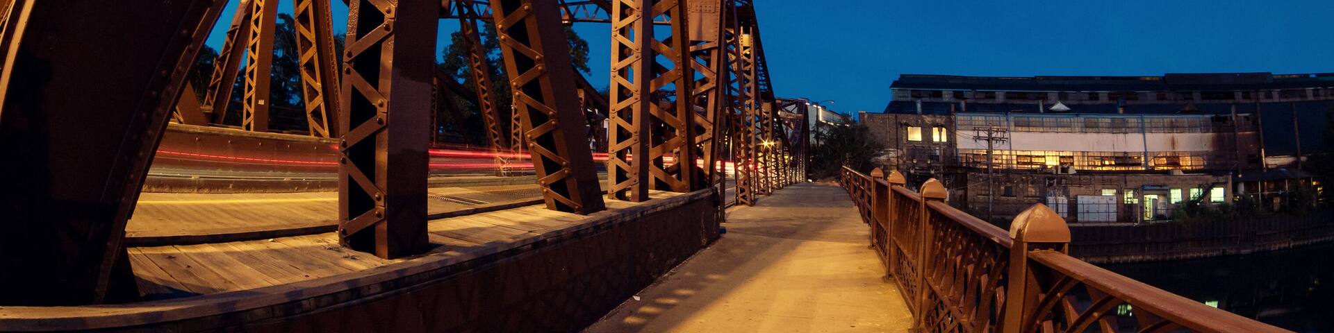 Vintage river bridge and industrial building at night