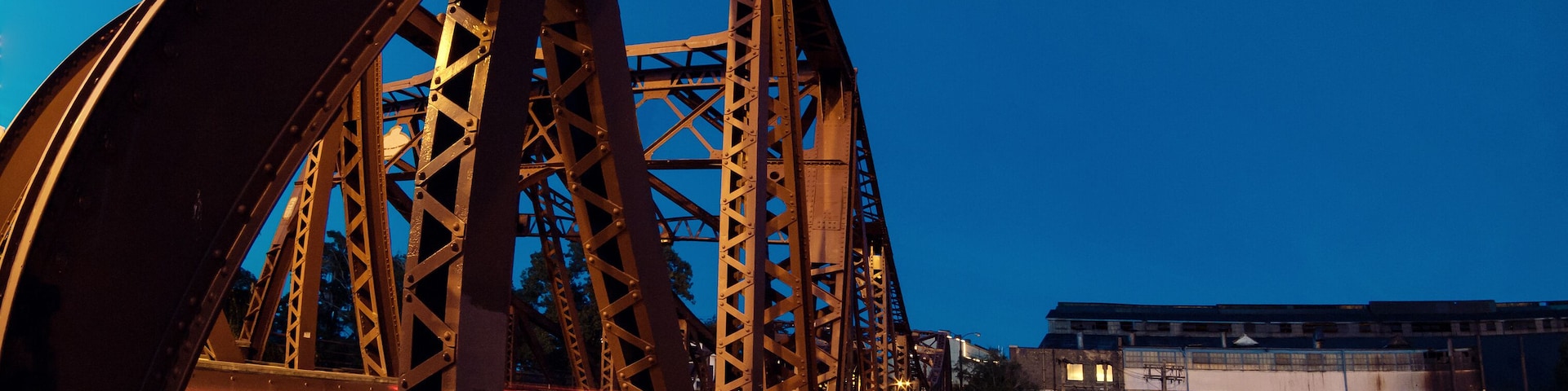 Vintage river bridge and industrial building at night
