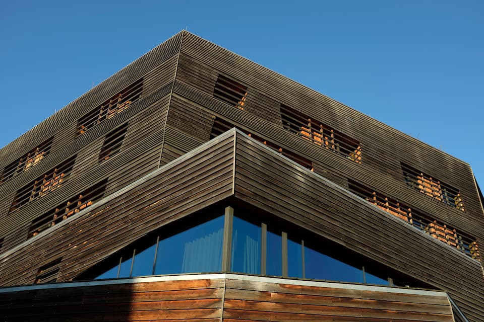 A modern building with a wooden facade and large windows.
