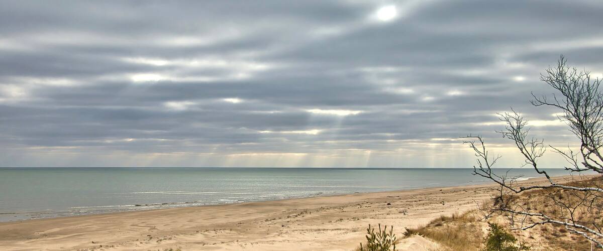 Moody Winter landscape of a long empty Lake Michigan beach near Point Beach State Forest on a cloudy day near Two Rivers, Wisconsin.
