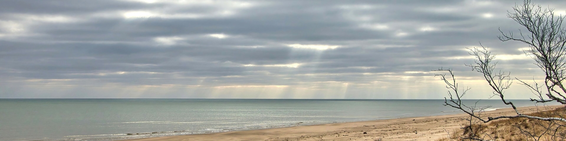 Moody Winter landscape of a long empty Lake Michigan beach near Point Beach State Forest on a cloudy day near Two Rivers, Wisconsin.