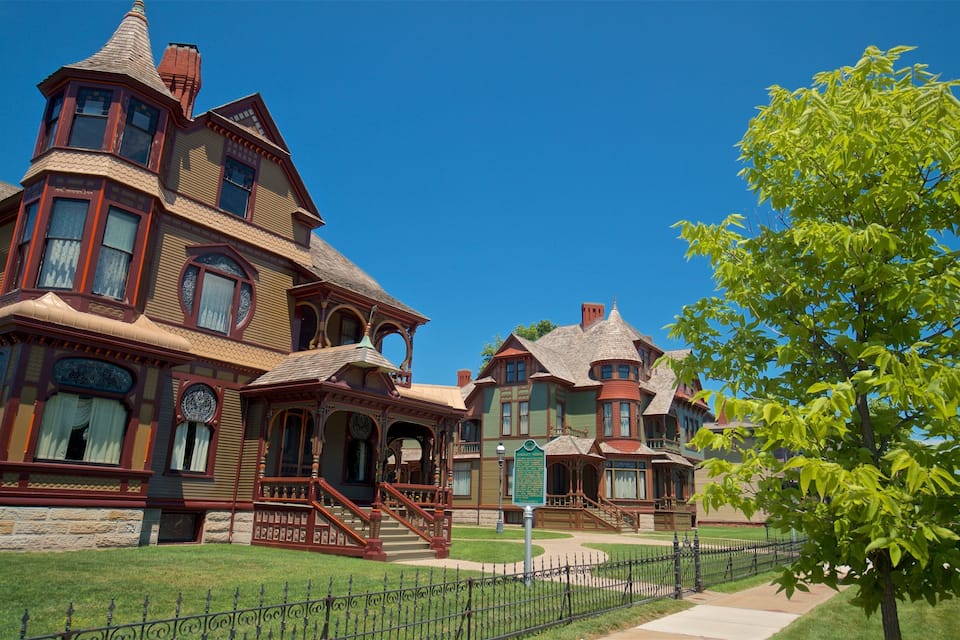 A large, ornate Victorian-style house with multiple towers and intricate woodwork.