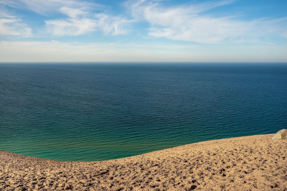 Una platja amb una vista clara de l'oceà i una riba rocosa.