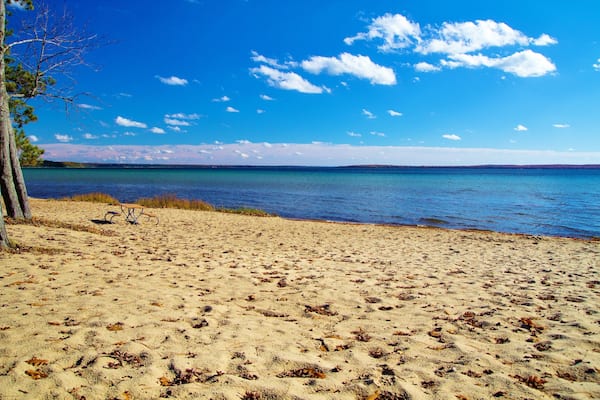 Wide sandy beach and an aquamarine horizon. North Higgins Lake State Park encompasses much of the shore of Higgins Lake; voted the sixth most beautiful lake in the world by National Geographic. ; Shut