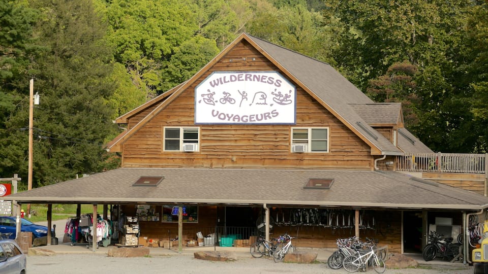 A wooden building with a sign reading "WILDERNESS VOYAGEURS" and bicycles parked outside.