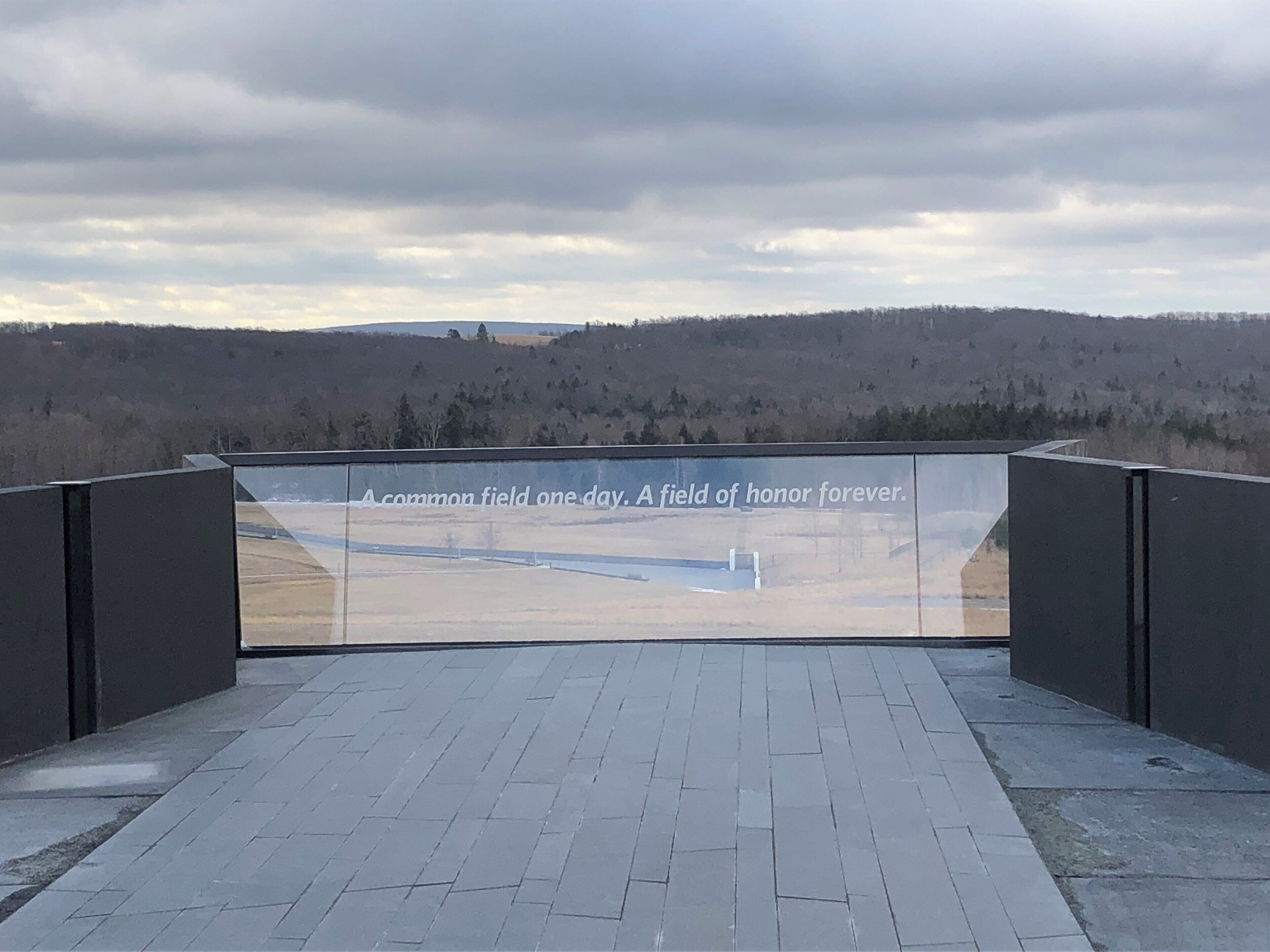 A memorial with a reflective surface and a quote.