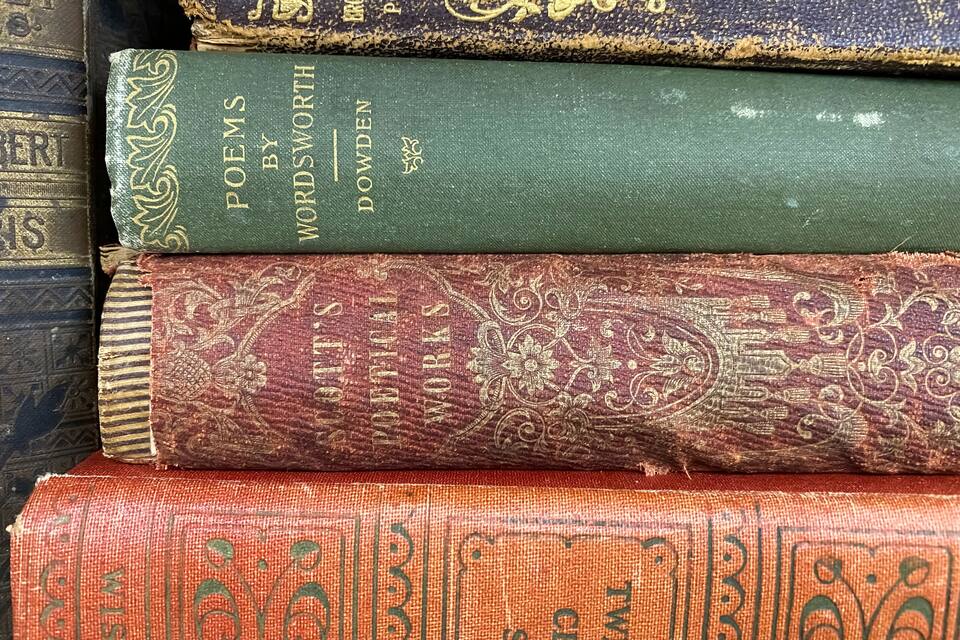Une pile de vieux livres dont on peut voir les titres et les noms des auteurs.