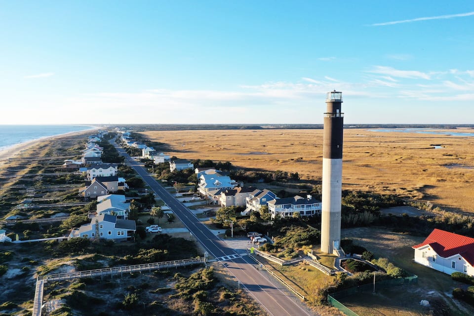 Une ville côtière avec des maisons, un phare et une plage.
