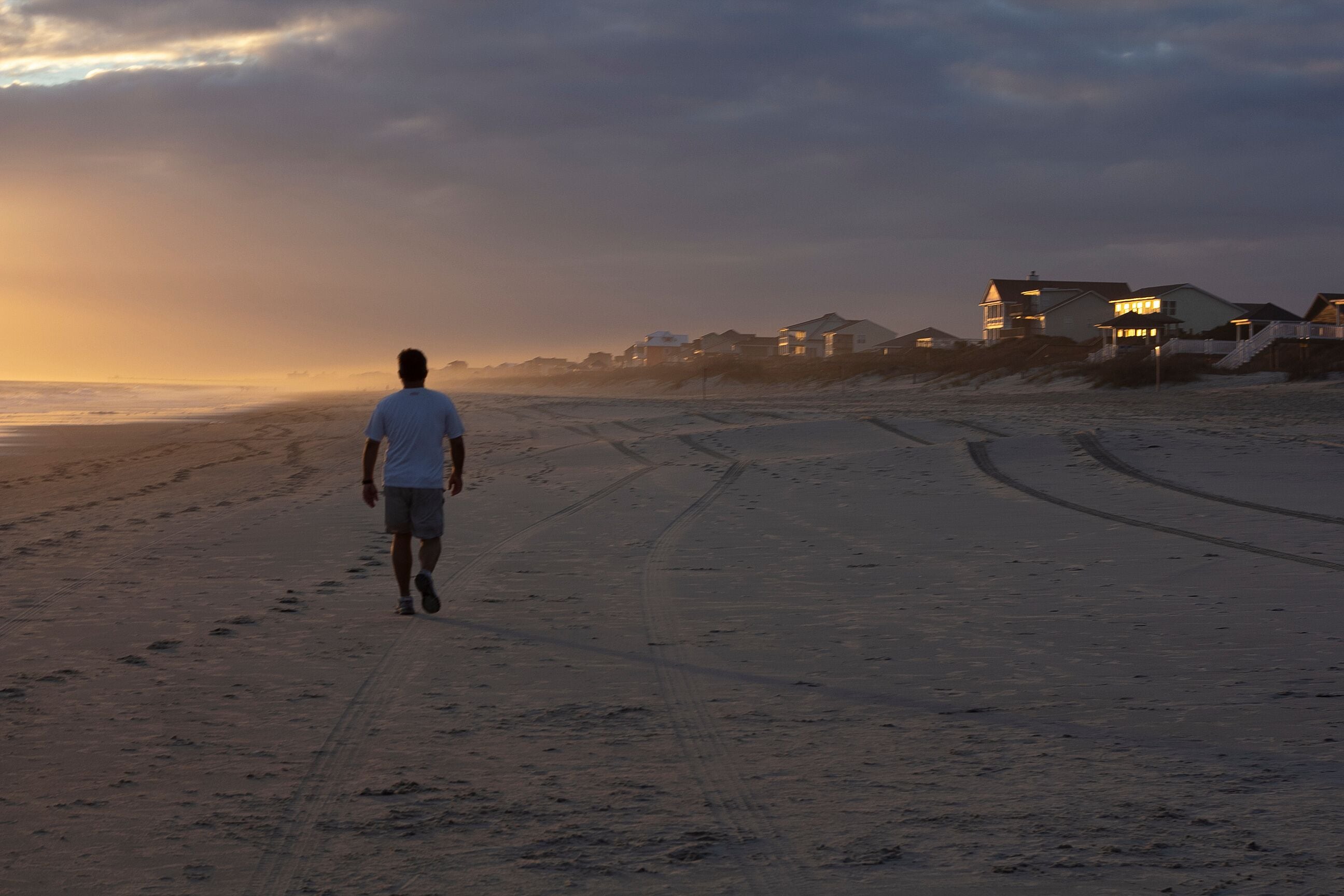 Man Walking on Beach at Sunset