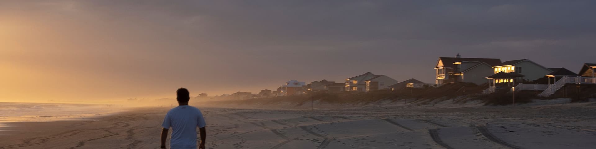 Man Walking on Beach at Sunset