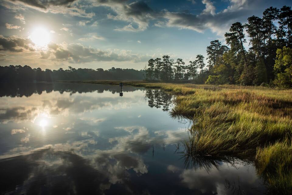 Een rustig meer dat de lucht en bomen weerspiegelt.