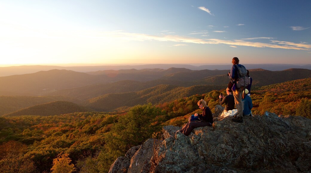 Parque Nacional Shenandoah mostrando montañas y una puesta de sol y también un pequeño grupo de personas