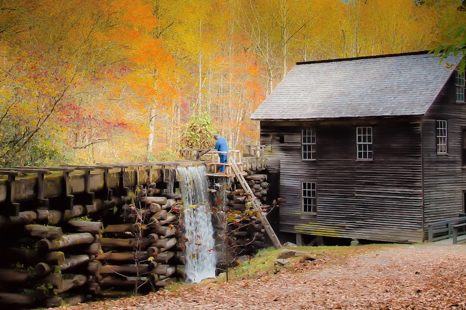 Una casa di legno con una cascata in una foresta.