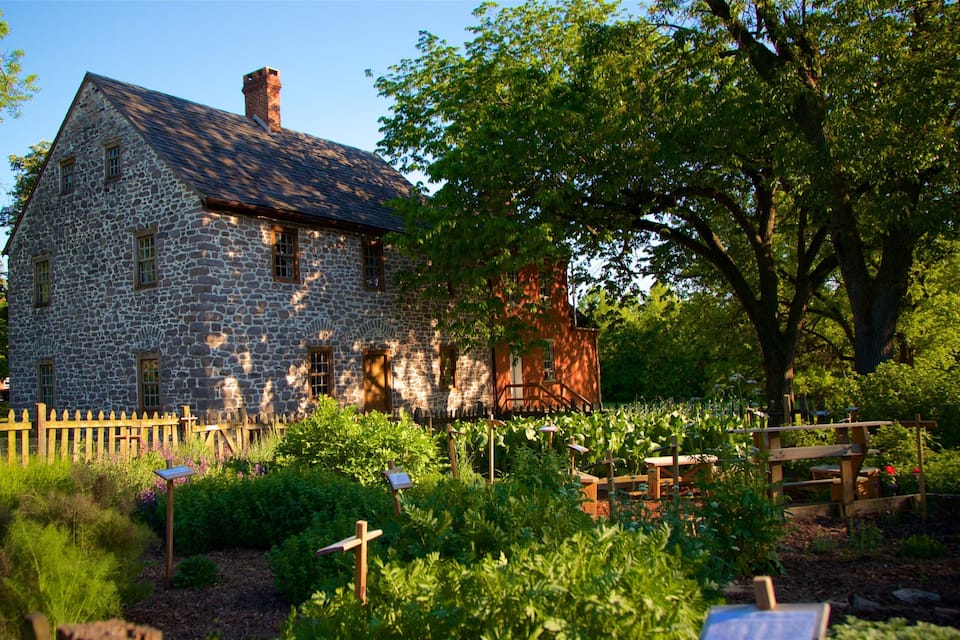A stone house with a wooden fence and garden.