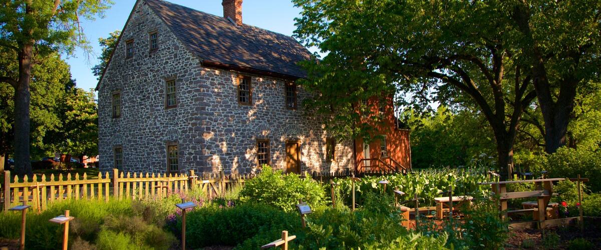 A stone house with a wooden fence and garden.