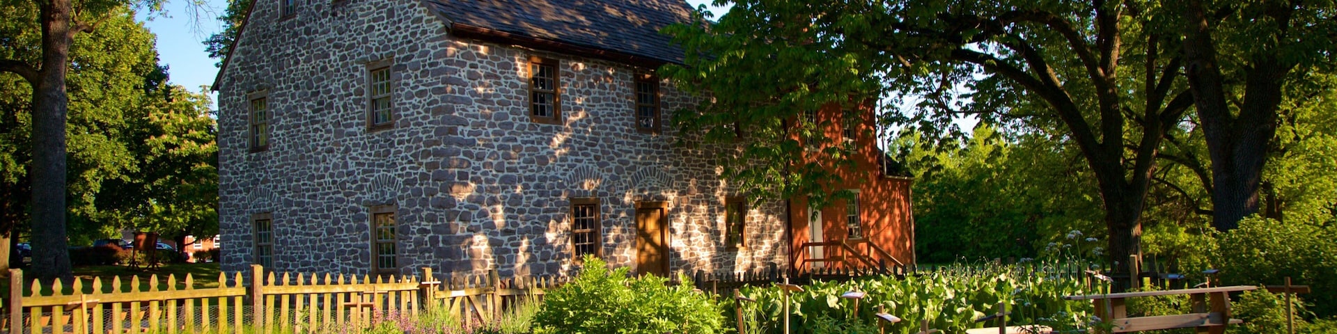 A stone house with a wooden fence and garden.