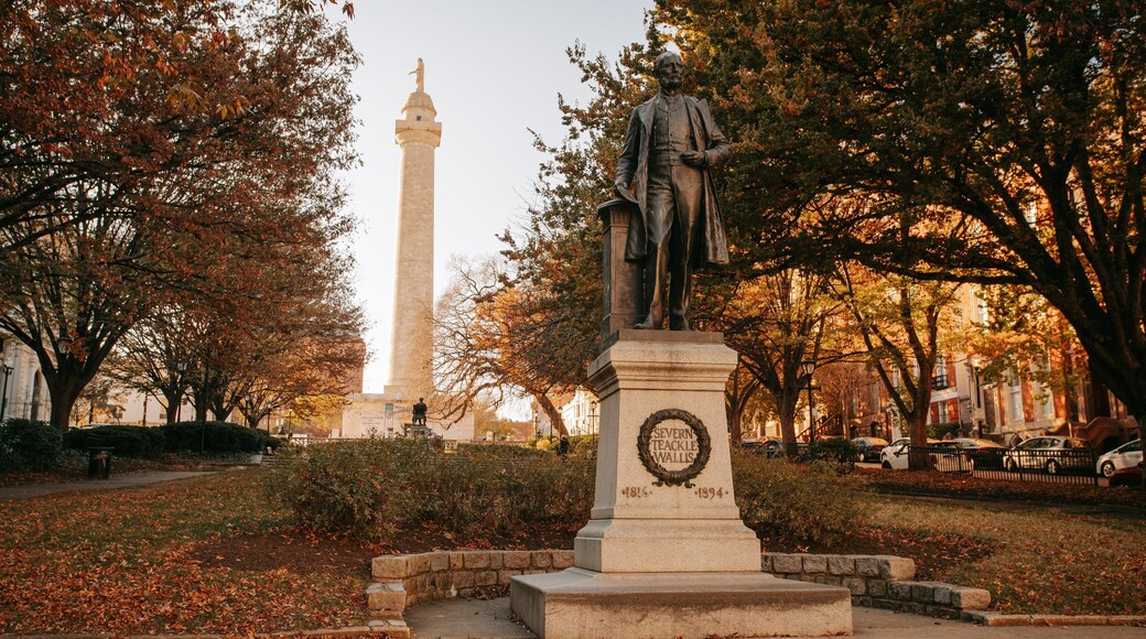 George Peabody Library featuring a statue or sculpture, a park and autumn leaves