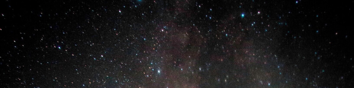 Un observatoire en forme de dôme, sous un ciel étoilé où l’on peut distinguer la Voie lactée et des étoiles filantes.