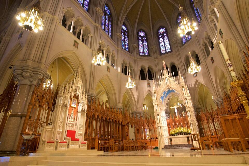 A grand cathedral interior with ornate Gothic architecture, stained glass windows, and a central altar.