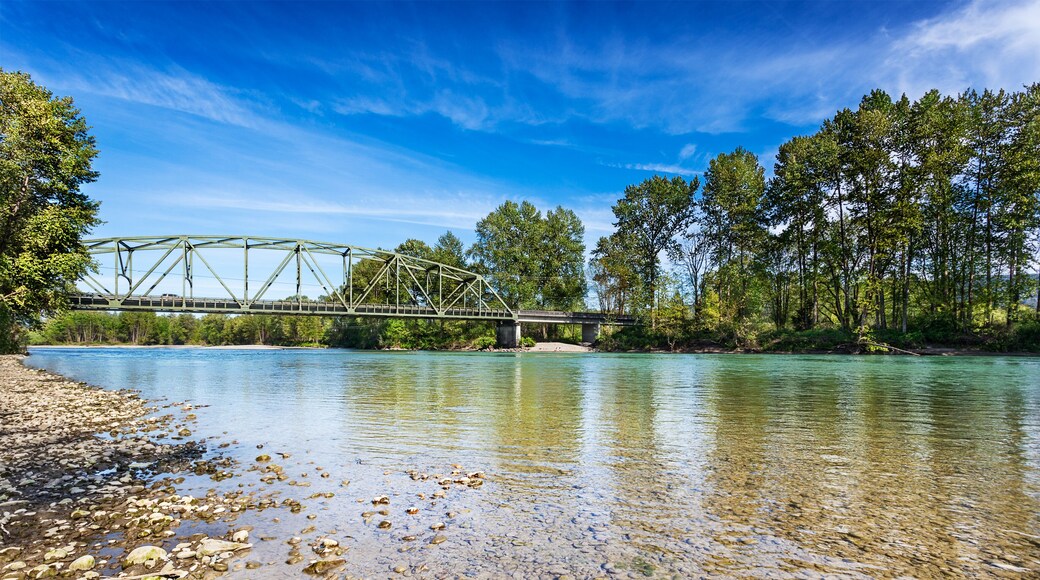 Calm Spring afternoon on the Skykomish River in Monroe, Washington by the Lewis Street bridge. The through truss bridge is state highway 203; Shutterstock ID 411400924