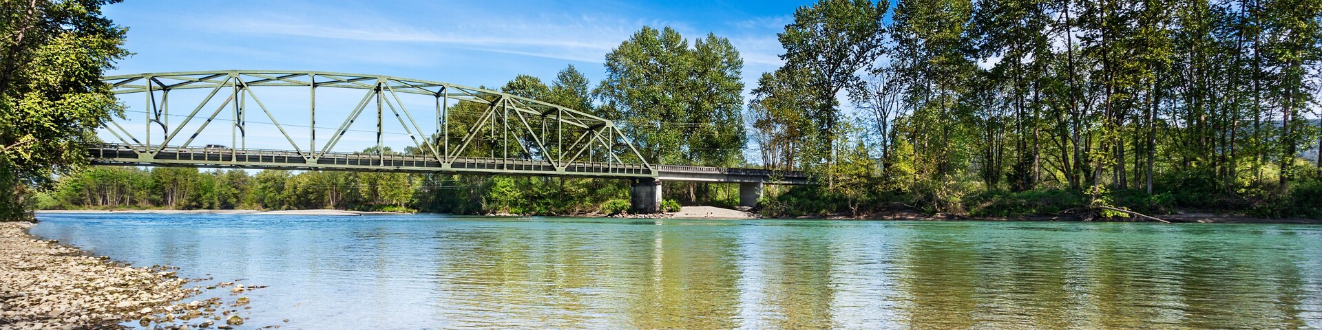 Calm Spring afternoon on the Skykomish River in Monroe, Washington by the Lewis Street bridge. The through truss bridge is state highway 203; Shutterstock ID 411400924