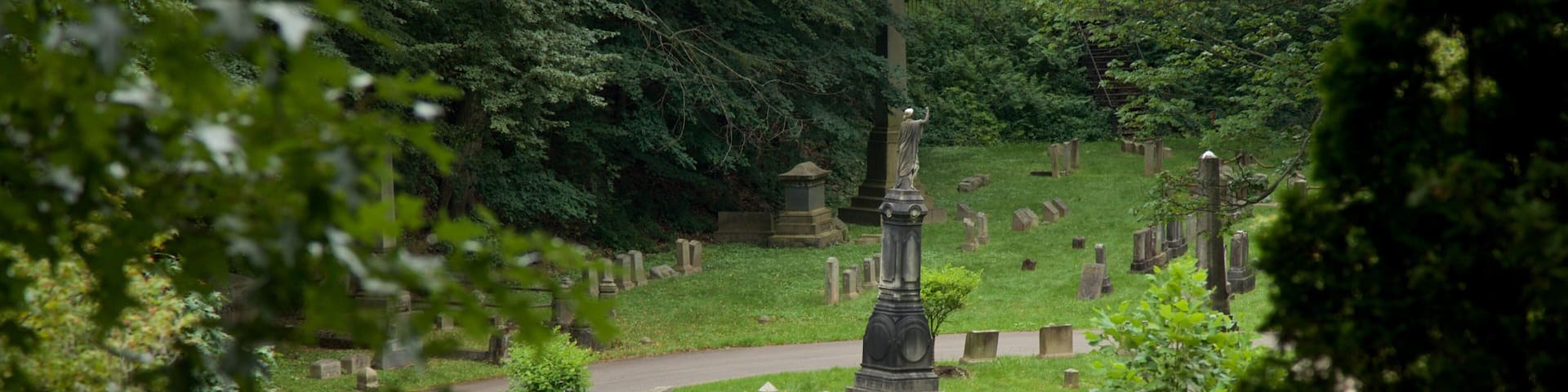 A cemetery with numerous gravestones and a central monument.