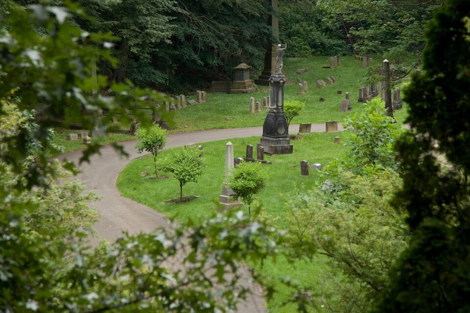 A cemetery with numerous gravestones and a central monument.
