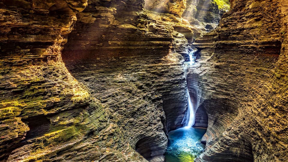 A canyon with a waterfall and a river.