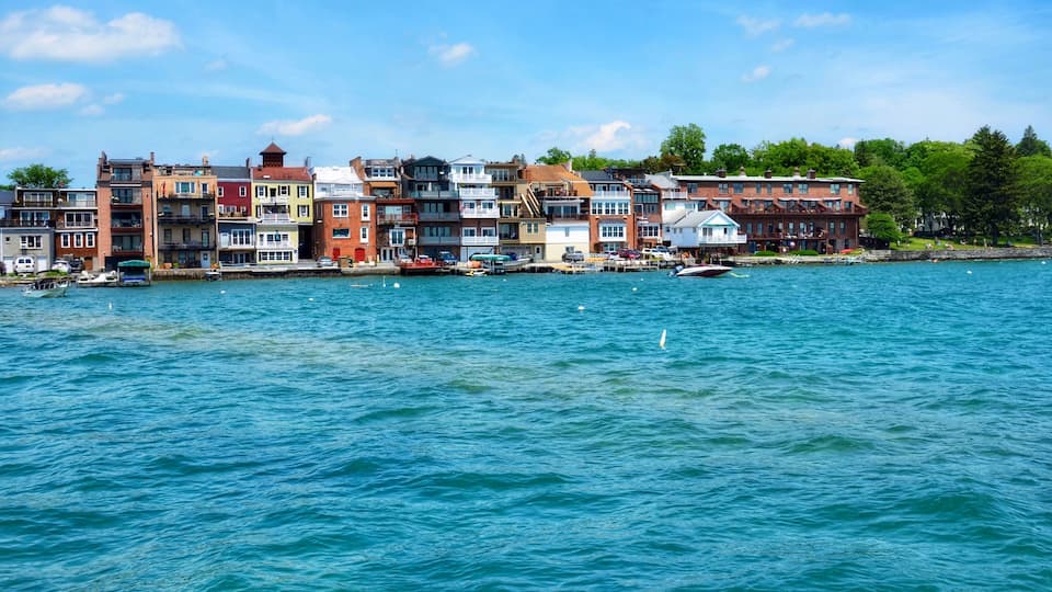 A waterfront with colorful buildings and boats docked along the shore.